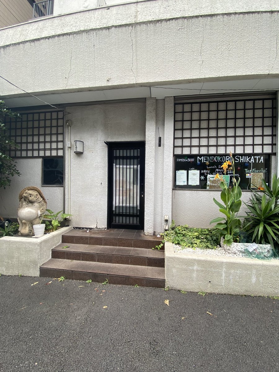 閉店の3日前、2022年7月6日の開店前。「RAMEN and BEER MENDOKORO SHIKATA」の黒板と、狸の置物
